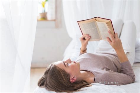 Free Photo Young Woman Lying On Bed Reading Book