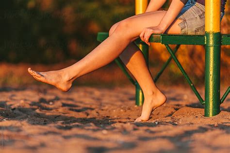 Woman Sitting On Beach Bench Swinging Legs By Ilya
