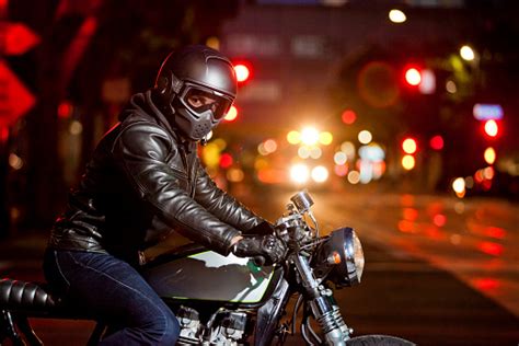 Motorcycle Rider At Night On Busy Street Stock Photo Download Image