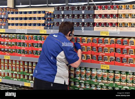 Supermarket Shelf Stacking Tins Of Soup And Stew At Aldi Supermarket