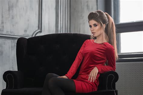 Girl In Red Dress Sitting On A Sofa