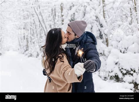 Couple Love Story In Snow Forest Kissing And Holding Sparklers Couple In Winter Nature Couple