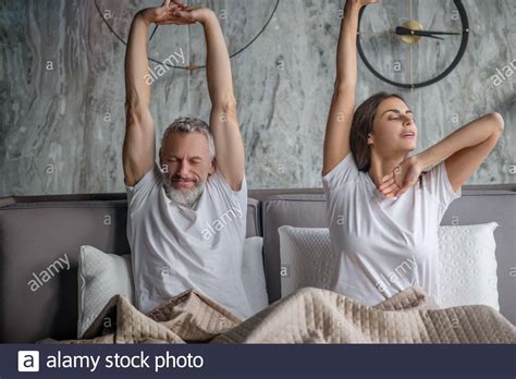 Man And Woman Waking Up Stretching In Bed Stock Photo Alamy