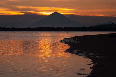 Dramatic Golden Sea Sunset With Dark Volcano In Distance Island With