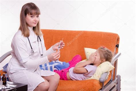 Doctor preparándose para hacer de una niña una inyección fotografía de