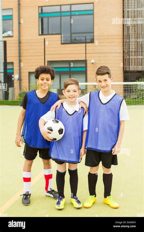 Retrato De Tres Niños Sonrientes Vistiendo Uniformes De Fútbol Y