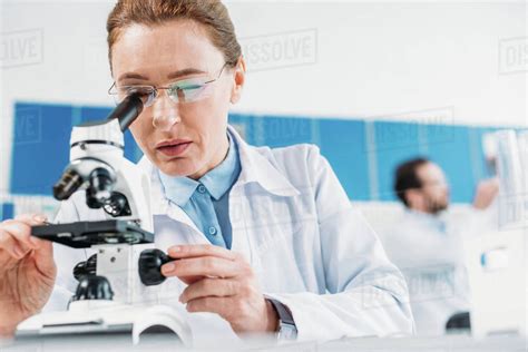 Selective Focus Of Female Scientist Looking Thorough Microscope On