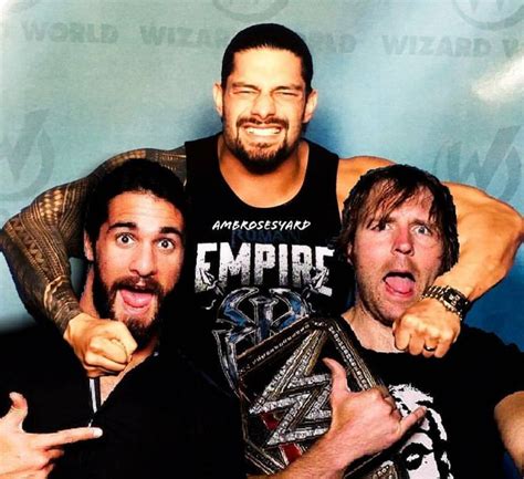 Three Men Posing For The Camera In Front Of A Blue Wall With An Emp Logo On It