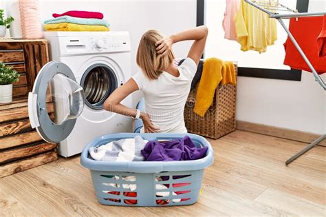 Young Caucasian Woman Doing Laundry With Clothes In The Basket