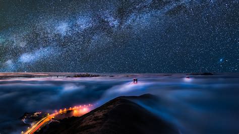 Clouds Covered Mountain Under Black Sky Full Of Stars During Night Time