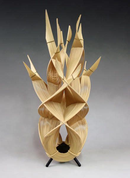 A Sculpture Made Out Of Folded Paper On Top Of A Black Stand With An