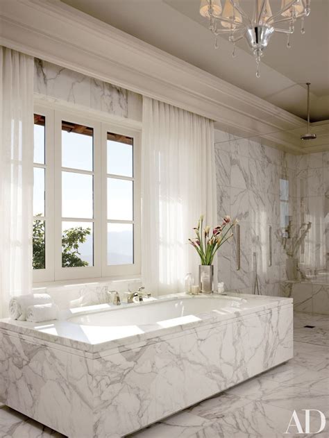 An Elegant Bathroom With Marble Walls And Floor Along With A Large