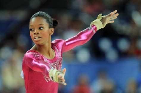 A Woman In A Pink Gymnastics Outfit Is Holding Her Arms Out And Looking At The Camera