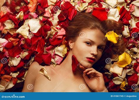 Portrait Of A Fashionable Red Haired Model In Rose Petals Stock Photo