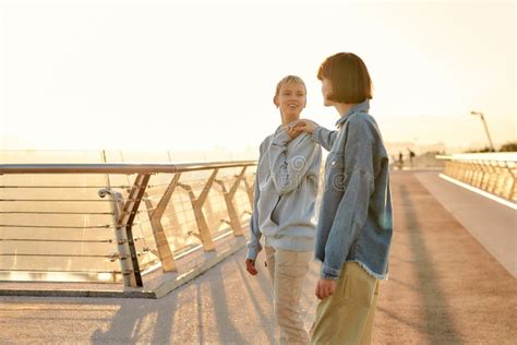 Happy Lesbian Couple Talking While Walking On The Bridge And Watching The Sunrise Together