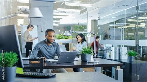 Busy International Office African American Man Working At His Desk On