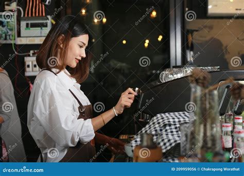 A Young Barista Girl Makes Coffee in a Coffee Shop. Work in a Coffee
