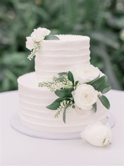 Simple And Elegant White Wedding Cake With White Flowers And Accent Greenery Captured By Lauren