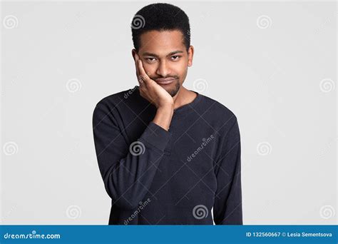 Black Sad Young Man Looks With Dejected Expression Holds Chin Has