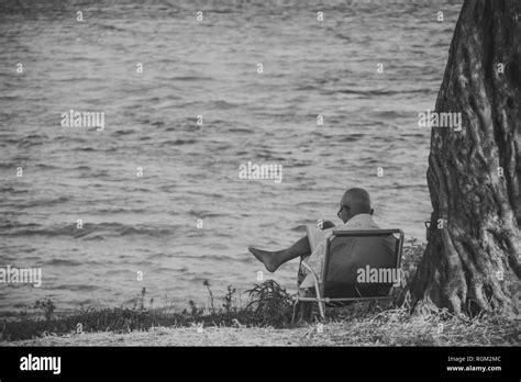 Man Sitting At The Beach In A Folding Chair Hi Res Stock Photography