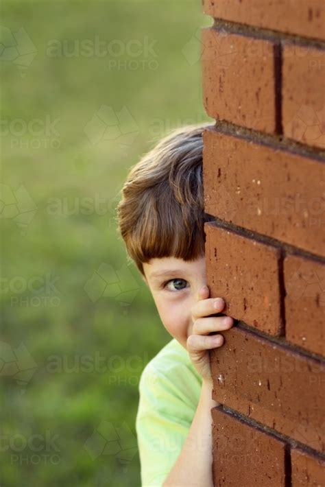 Image Of Portrait Of A Young Boy Looking Around The Corner Of The House