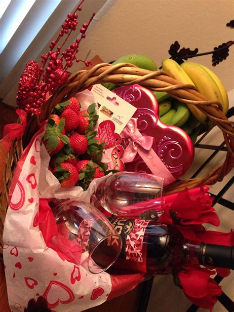 A Basket Filled With Fruit And Wine On Top Of A Table
