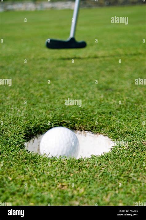 Golf Ball Putted Into Hole Stock Photo Alamy