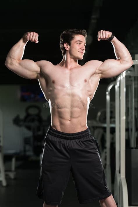 Bodybuilder Performing Front Double Biceps Pose In Gym Stock Photo