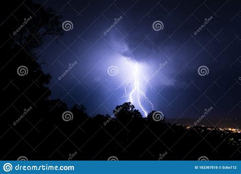 Lightning Hitting The Ground Framed By The Trees Stock Photo Image
