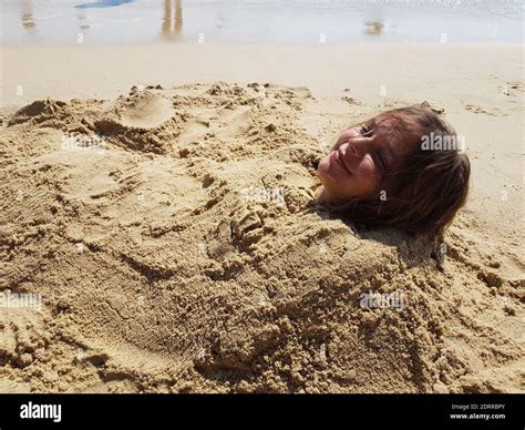 Girl Buried In Sand Hi Res Stock Photography And Images Alamy