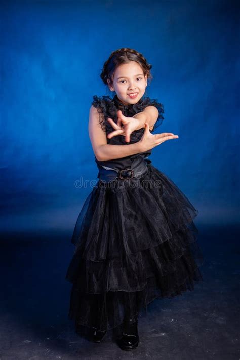 A Little Girl In A Black Dress With A Pigtail Hairstyle On Her Head