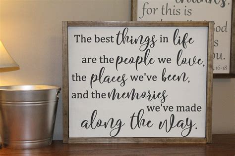 Two Framed Signs On A Table Next To A Lamp And A Cup With A Drink In It