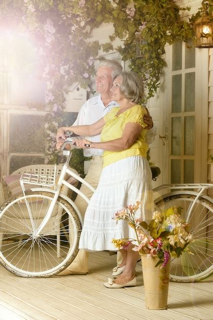 premium photo portrait of beautiful elderly couple on veranda with bicycle