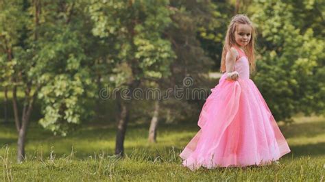 A Girl In A Pink Princess Dress Is Walk In The Park Stock Photo