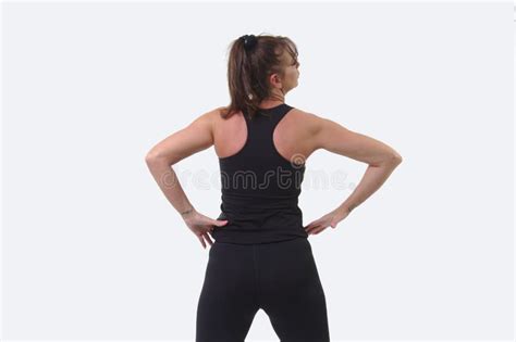 Attractive Middle Aged Woman In Sports Gear With Hands On Hips And Back