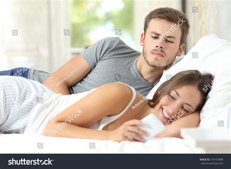 Jealous Gossip Husband Watching His Wife Mobile Phone On The Bed At