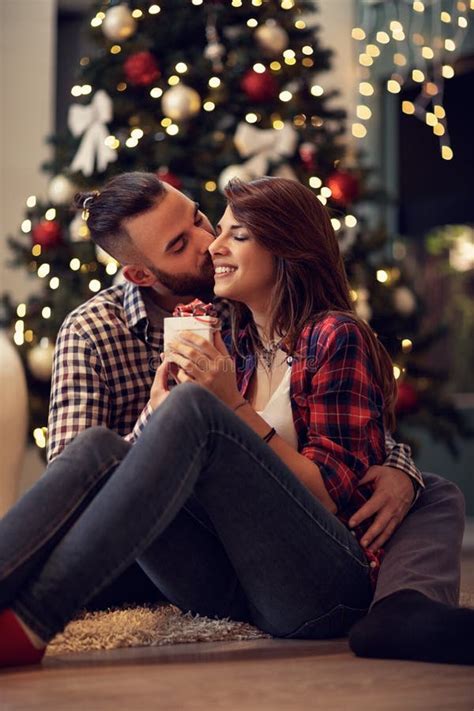 Husband Hug And Kisses His Wife While Gives Her Christmas Present Stock
