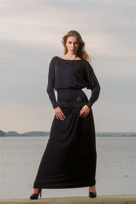 Attractive Fashion Model In Long Dress Posing On The Pier Stock Photo
