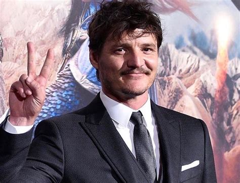 a man in a suit and tie making the peace sign with his hand at an event