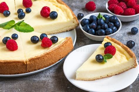 Classic Sliced New York Cheesecake With Fresh Berries And Mint On Stone