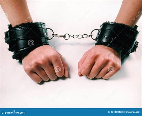 A Woman Hands Wearing A Pair Of Black Furry Leather Sex Toy Handcuffs