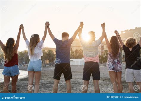 Amigos Que Mant M As M Os Junto Na Praia Foto De Stock Imagem De Praia Felicidade