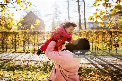 Mom Holding Toddler Above Her Head At The Park High Res Stock Photo