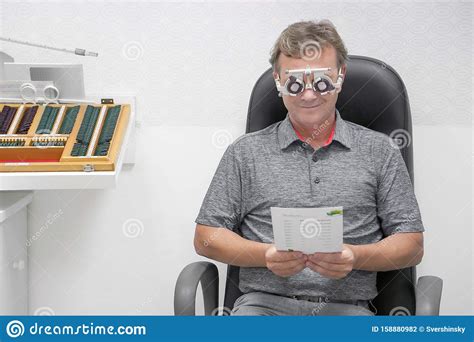 Optometrist Doing Sight Testing For Male Patient In Clinic Stock Photo