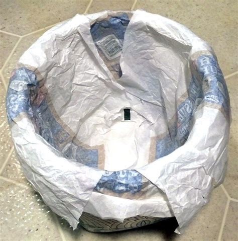 Choose toilet paper that's not wrapped in plastic. Using paper wrapper from toilet paper or newspaper to line ...