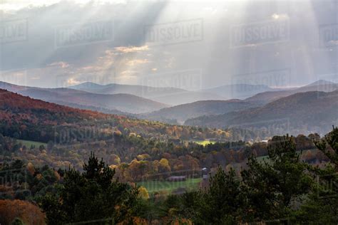 Sunlight Beams Through Clouds Above Mountains In Quechee Vermont