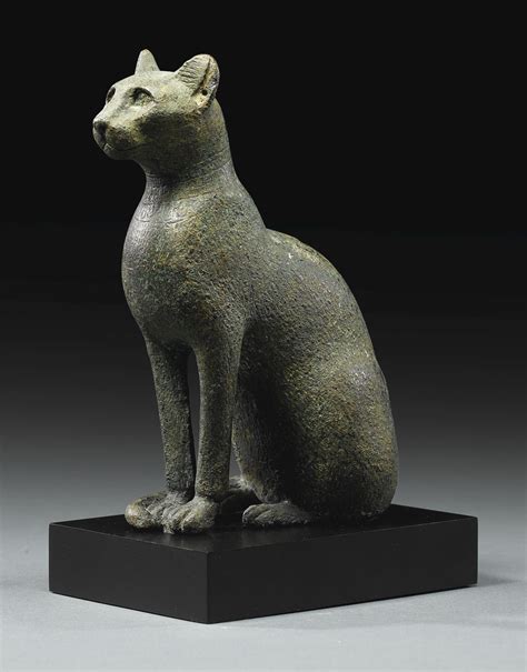A Statue Of A Cat Sitting On Top Of A Black Base
