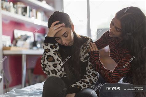 Teenage Girl Comforting Upset Friend On Bed — Hispanic Serious Stock