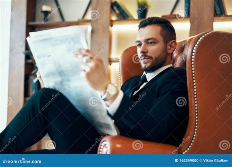 Confident Young Businessman Reading Newspaper And Latest News While