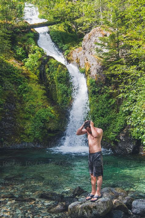 Man Standing In Front Of Waterfall After A Swim Del Colaborador De